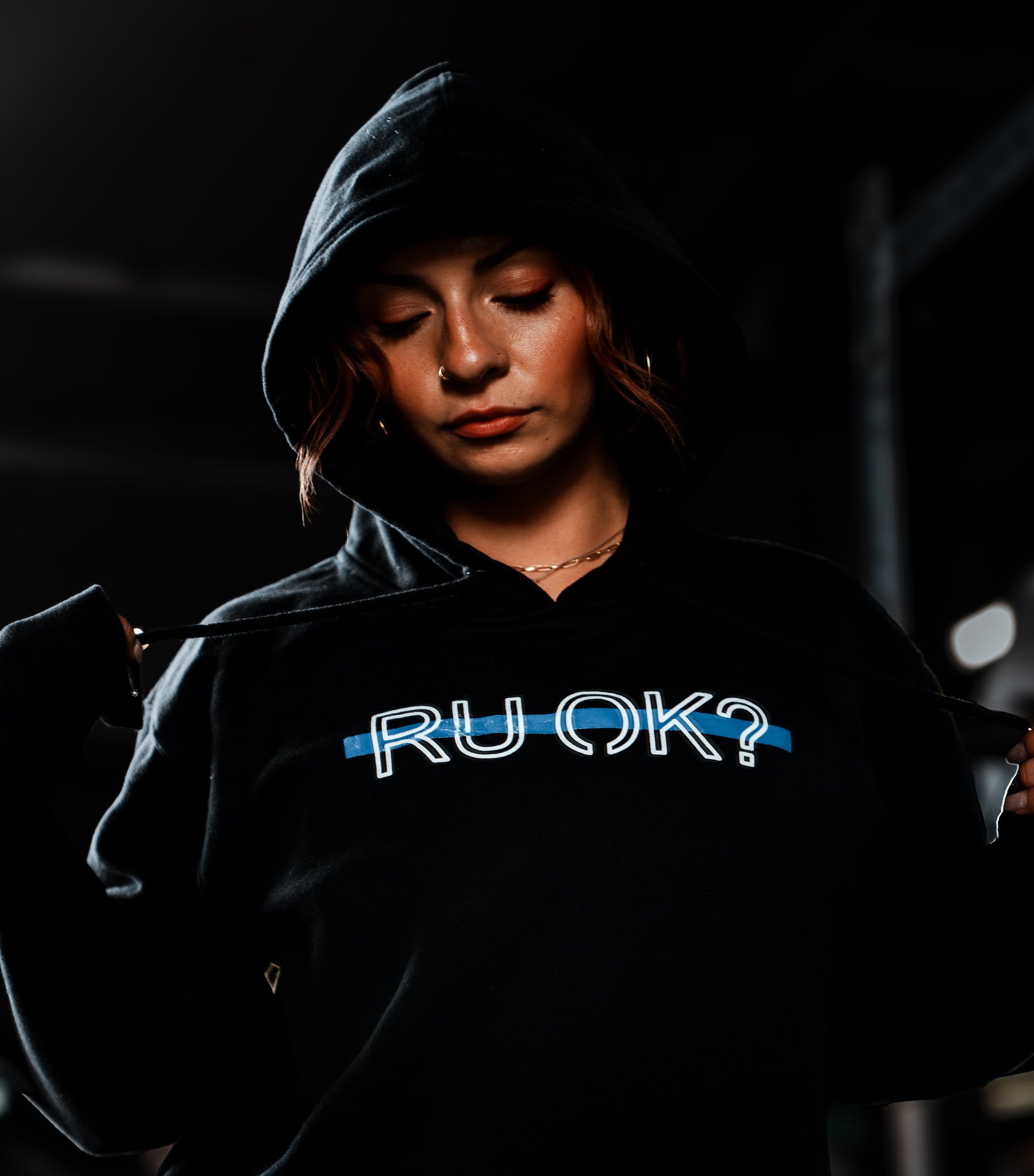 Person wearing a hoodie with 'RU OK?' text.