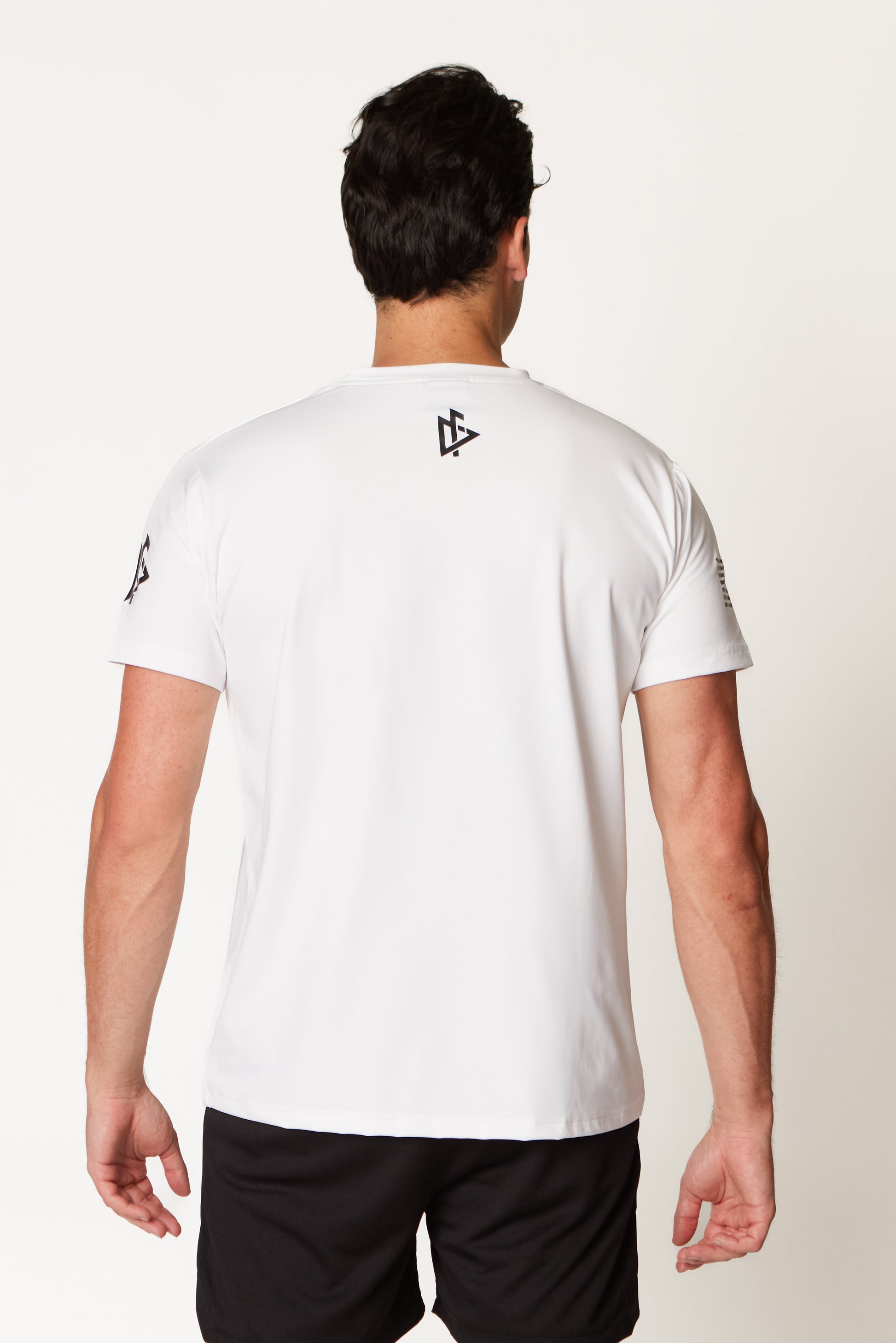 Back view of the Men’s Compellence Tee in white, highlighting shoulder fit and structure.