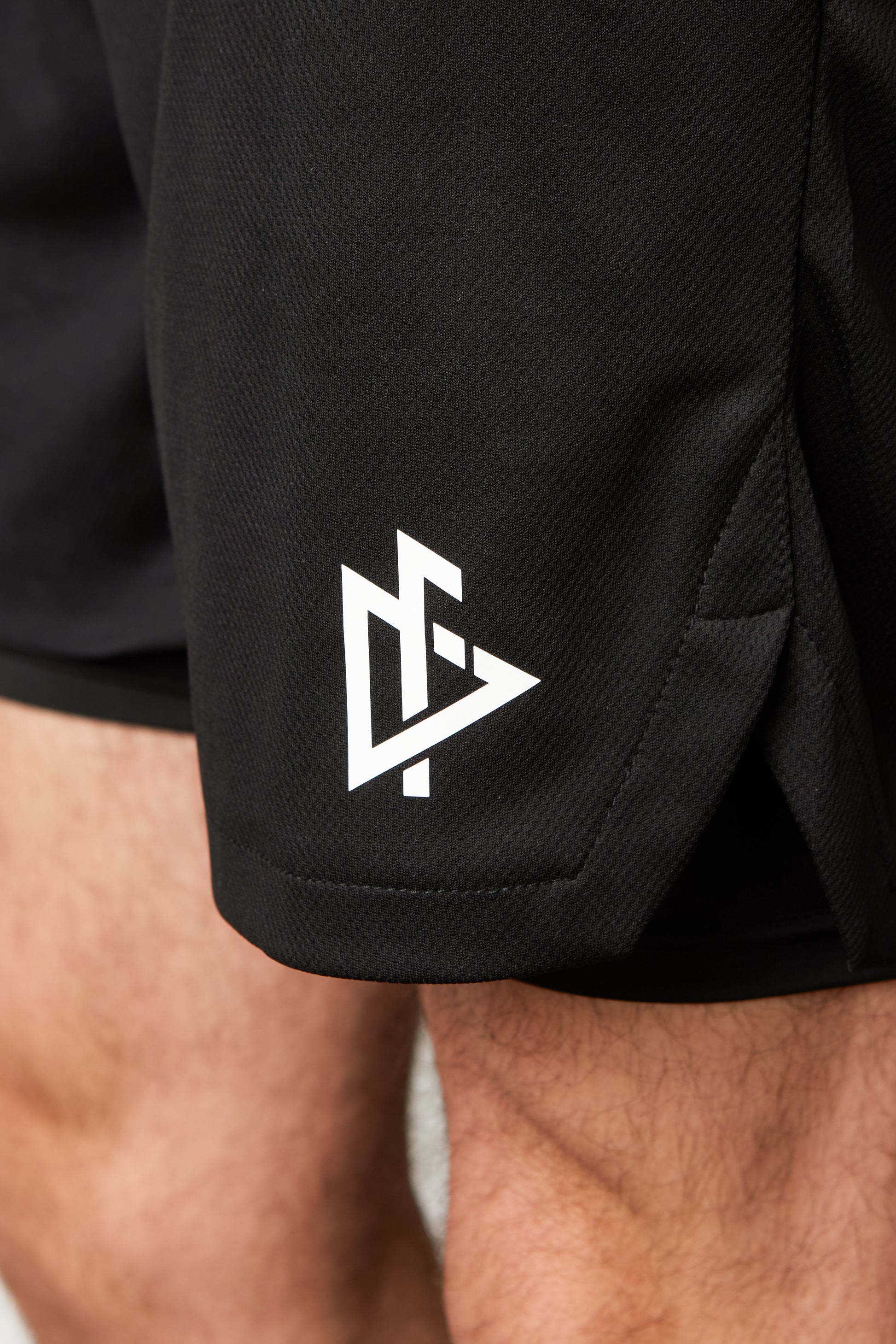 Close-up of drawstring waistband on black 5” liner mesh shorts for customizable fit.