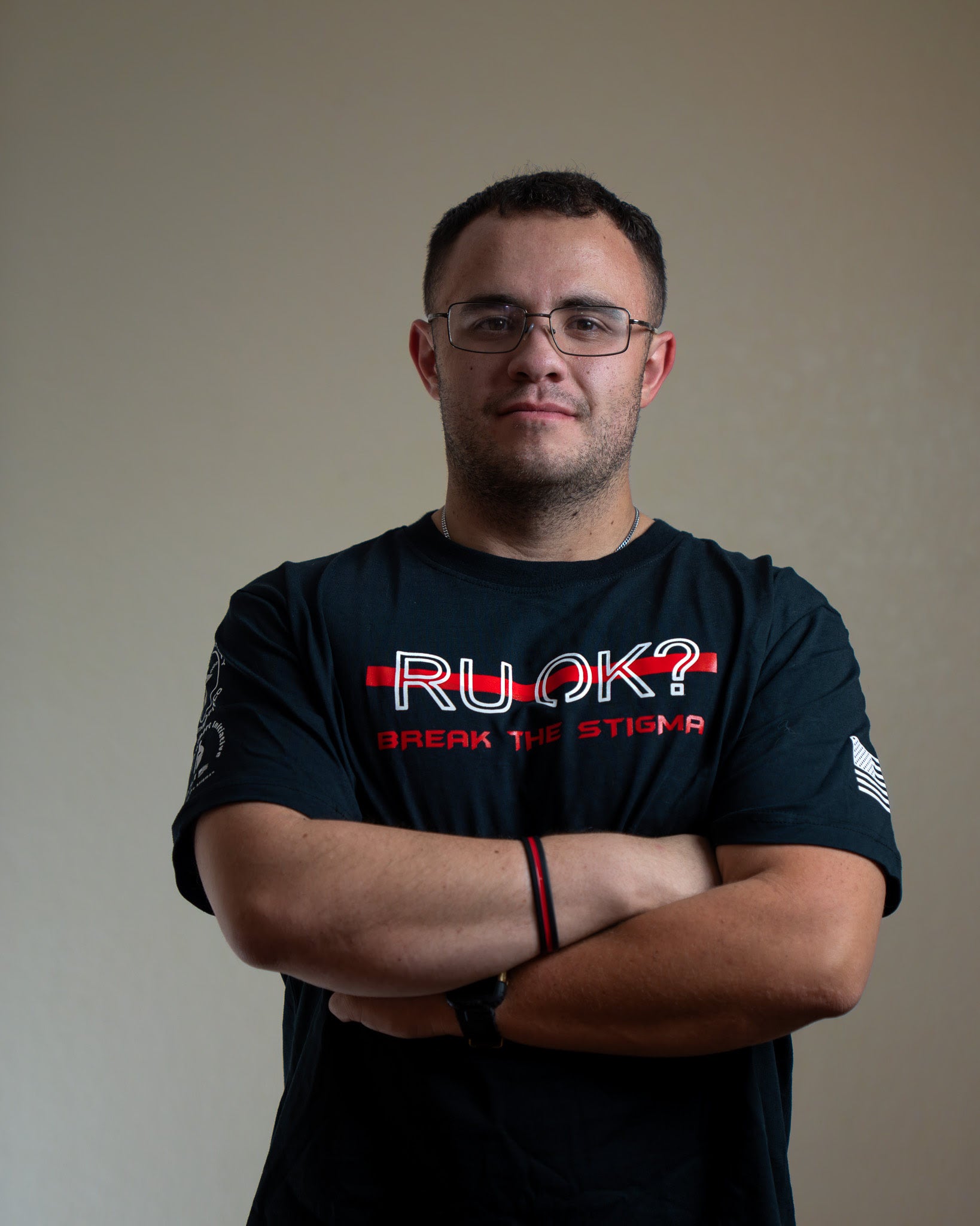 Man wearing a black t-shirt with 'RU OK?' text, standing against a plain background