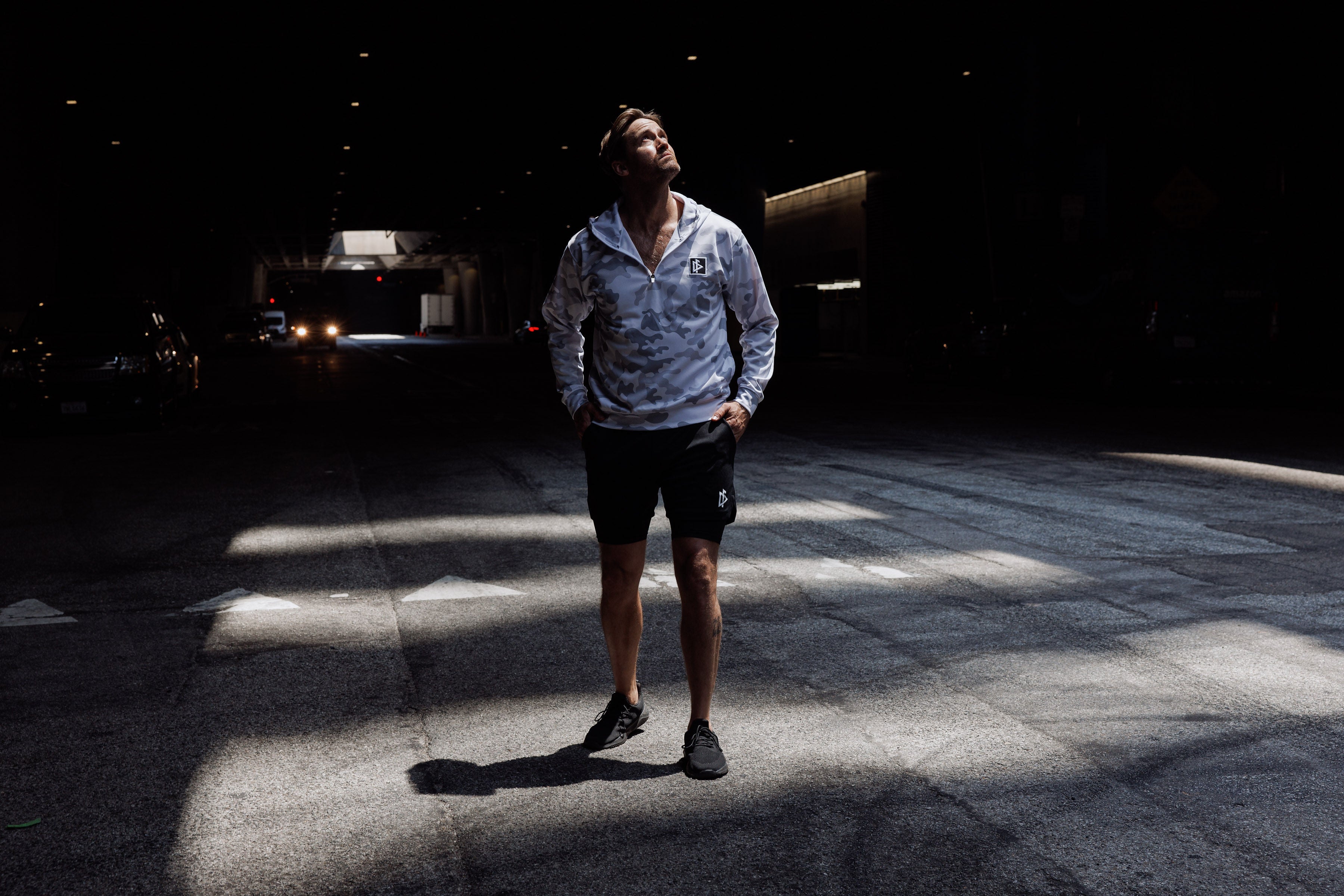 Person standing in a dark tunnel with light casting shadows