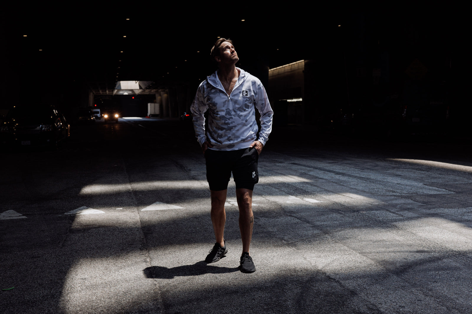Person standing in a dark tunnel with light casting shadows